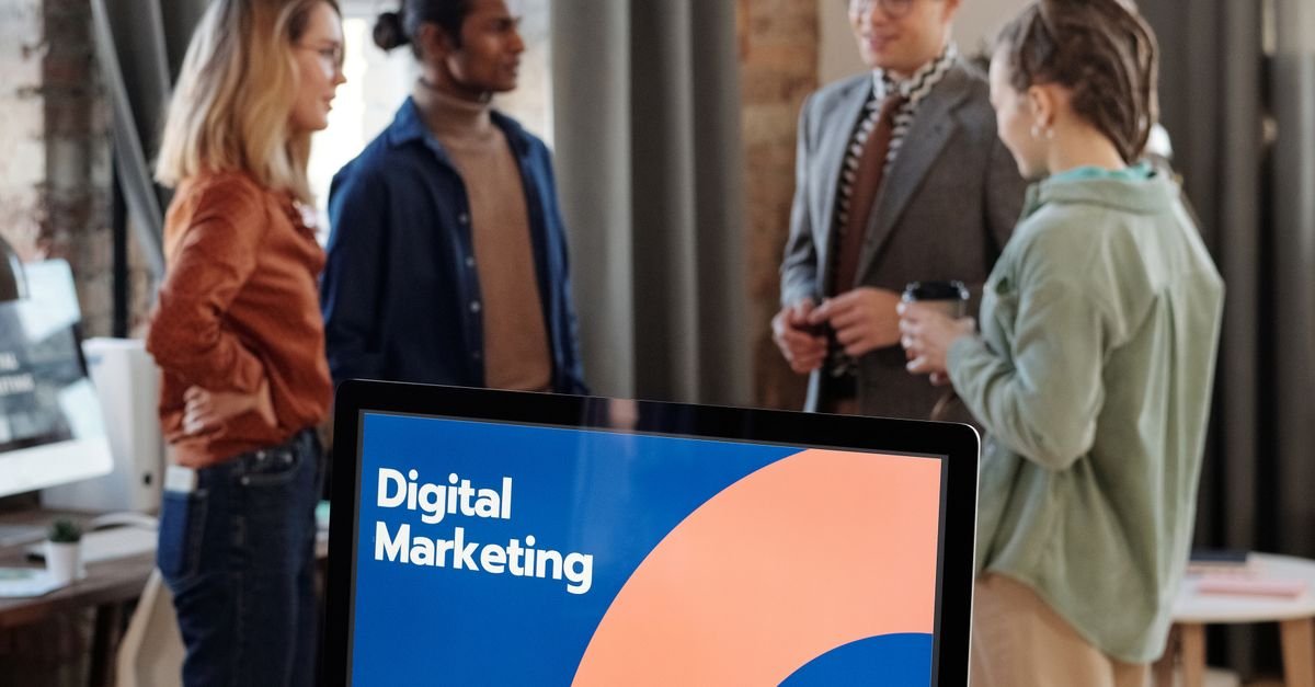 Business team engaged in a digital marketing discussion in a modern office setting.